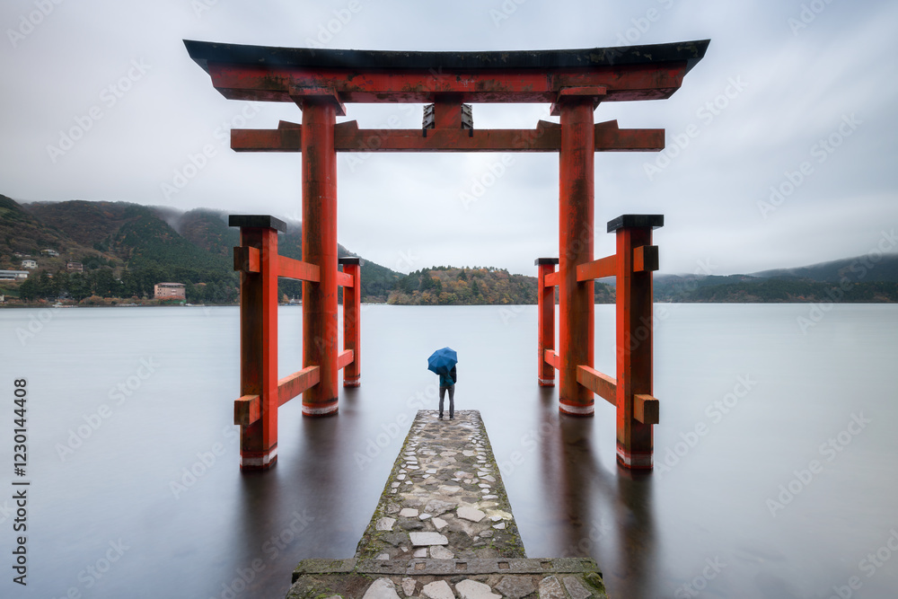 Person standing under red torii gate at Lake Ashi, Hakone, Kanagawa Prefecture, Japan