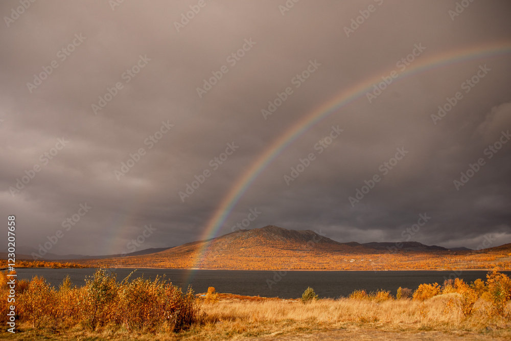 zwei regenbogen vor see und dunklen wolken zwei regenbogen vor see und dunklen wolken