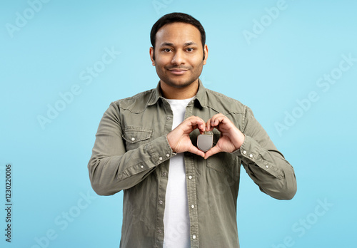 Man showing heart shaped hands holding pacemaker device on chest photo