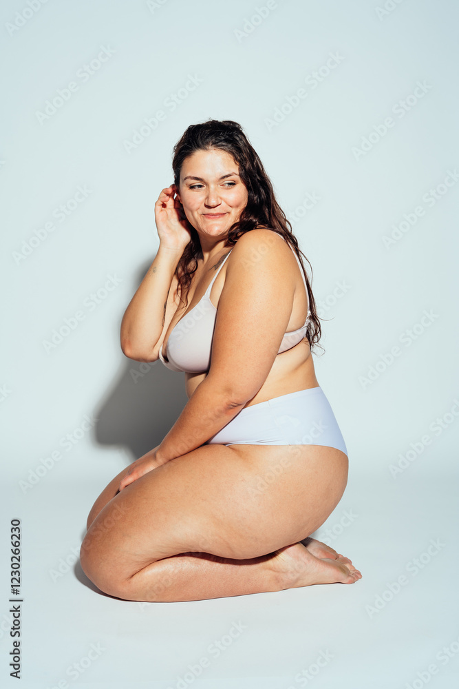 Fototapeta premium Plus size woman posing in studio in lingerie