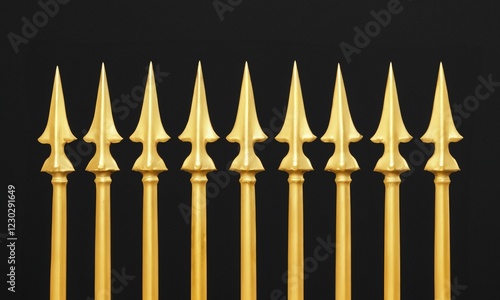Ornate gold metal fence with sharp spearheads on a black background. Rustic wrought iron fence design element. Detail of pointed golden iron gates isolated on a black background. Copy space.