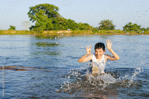 Joyful child splashing in colombian river photo