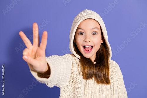 Slika na platnu Charming young girl in a casual hoodie smiling joyfully against a purple backgro