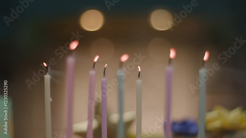 Slow-motion shot of blowing out multiple candles on a birthday cake, with flames flickering and smoke rising. Perfect for celebration, joy, and special moments themes