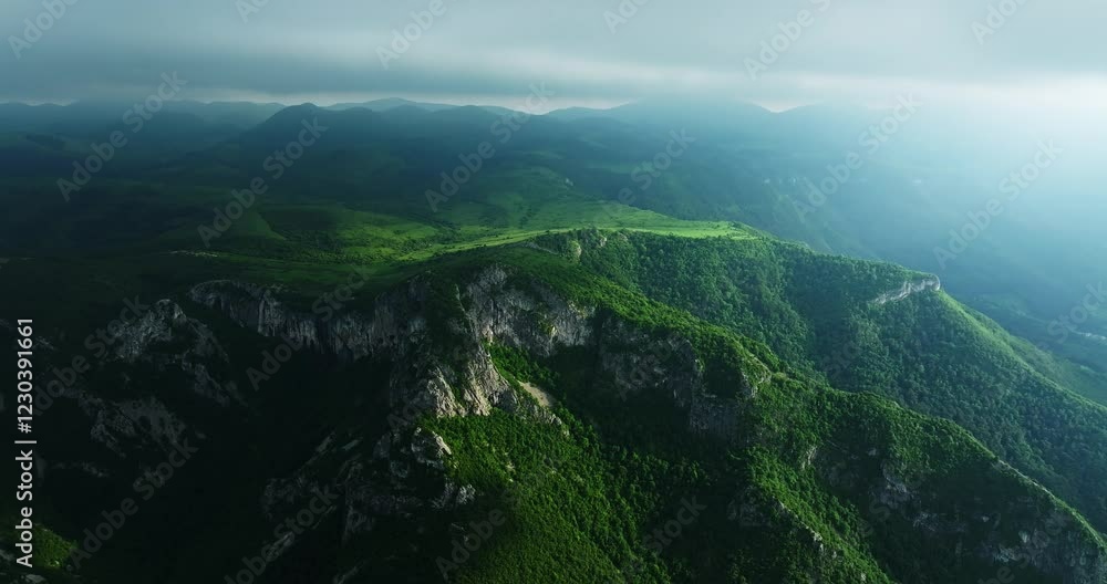 Vast Mountain Range Cliffs Ledges Overlooking Small Village Aerial Orbit Shot Vast Mountain Range Cliffs Ledges Overlooking Small Village Aerial Orbit Shot