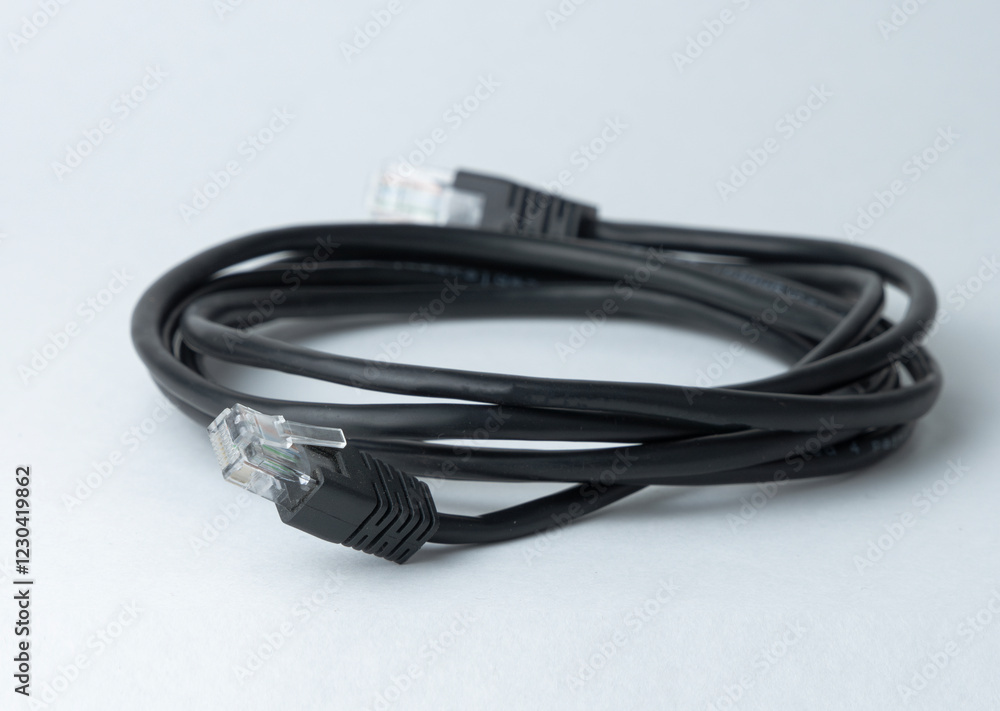 Black ethernet cable lying on a plain surface Black ethernet cable lying on a plain surface