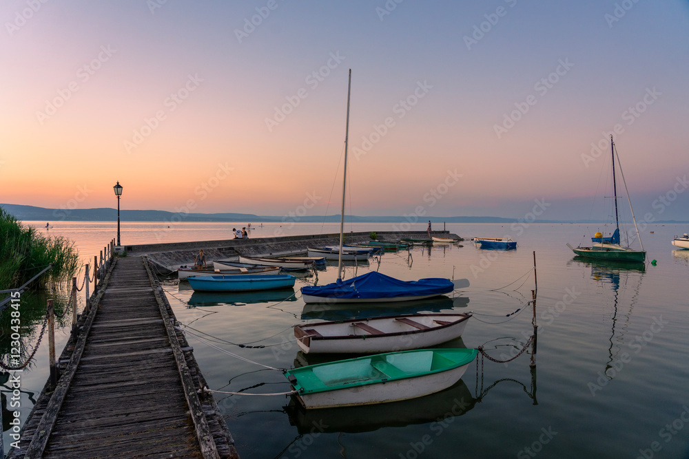 Fototapeta premium calm idyllic picture about boats next to the pier at sunset in Balatonlelle at Lake Balaton