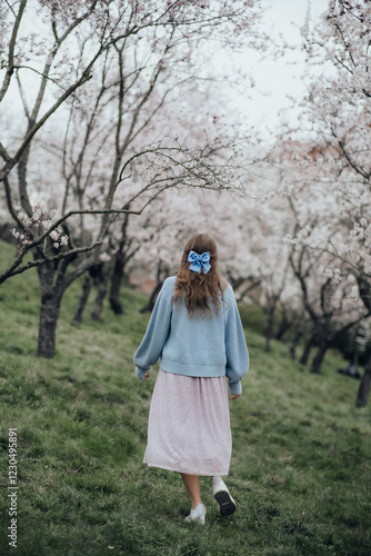 Girl in the garden with a blue bow on her hair