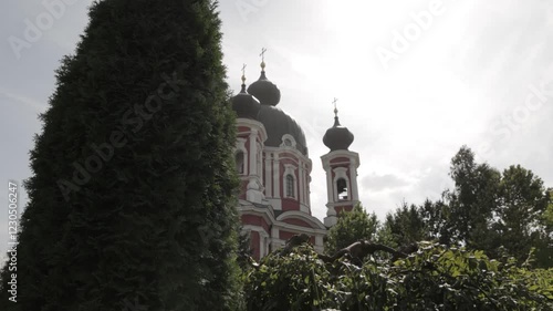 Tall Red Painted Orthodox Church in a Park with Trees