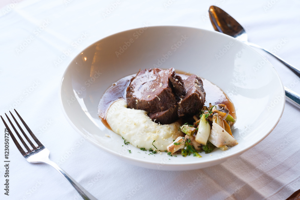 A delectable dish featuring slow cooked meat creamy mashed potatoes and roasted vegetables A delectable dish featuring slow cooked meat creamy mashed potatoes and roasted vegetables