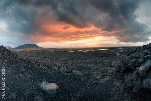 A stunning sunset casts vibrant hues over the rugged volcanic landscape of Iceland, where dark clouds loom dramatically overhead
