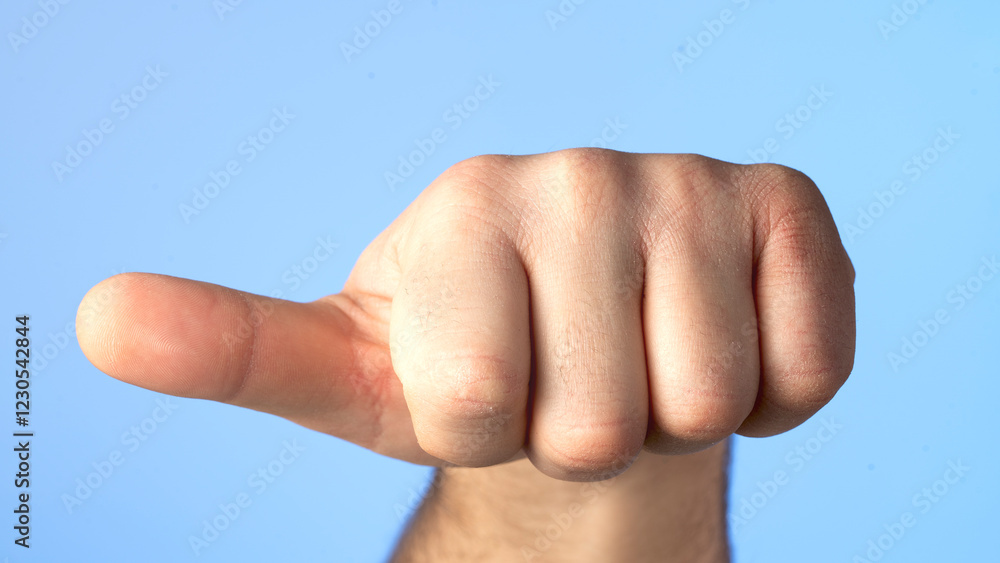 A hand with a fist raised and a finger pointing to the left. Concept of determination and strength A hand with a fist raised and a finger pointing to the left. Concept of determination and strength