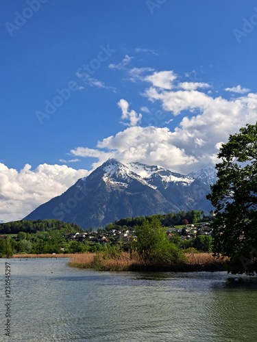 A lake in the Swiss Alps. The Blue Lake in Switzerland. Snow-capped mountains near the lake. Spring.