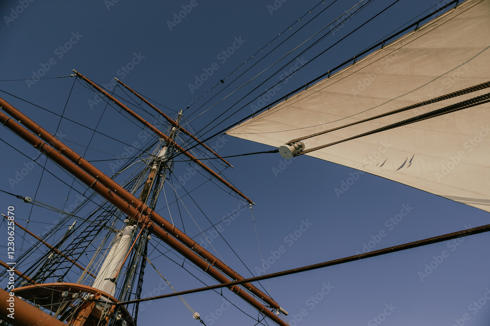 Tall Ship Sails and Rigging along the Harbor under a Cloudless Blue Sky Tall Ship Sails and Rigging along the Harbor under a Cloudless Blue Sky