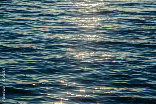 Fototapeta Naklejka Na Ścianę i Meble -  Sunlight Sparkling off a Calm Ocean at Sunset