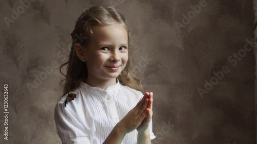 The girl looks with interest at the butterfly on her hand.Live butterflies are sitting on a girl.The girl holds a live butterfly in her palms and studies it.The butterfly takes off from the hand