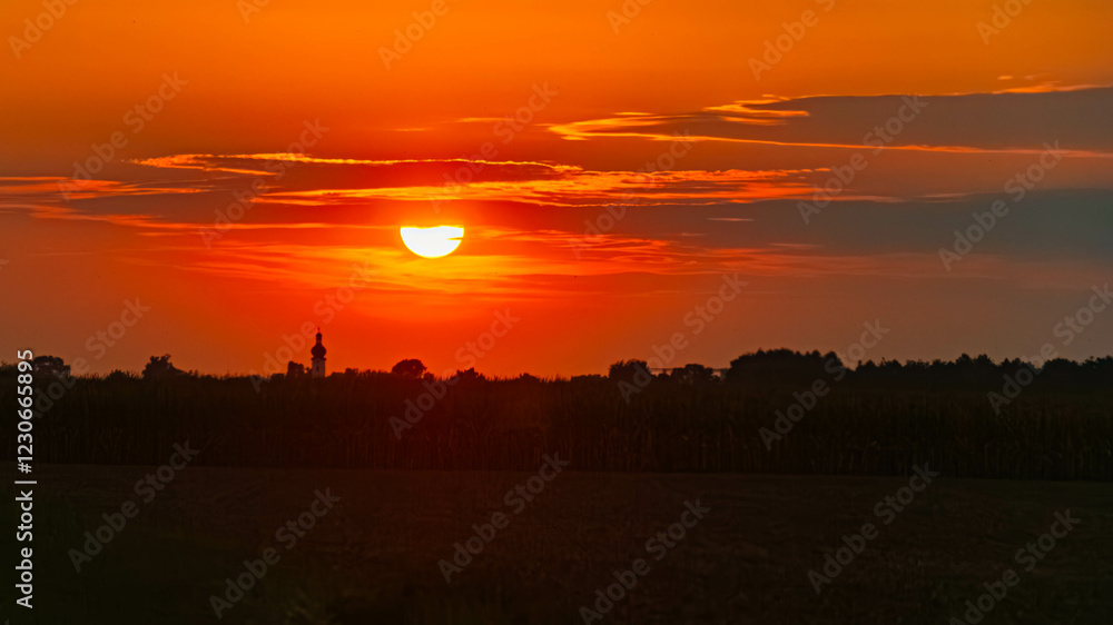 Summer sunset with a church silhouette near Buchhofen, Deggendorf, Bavaria, Germany Summer sunset with a church silhouette near Buchhofen, Deggendorf, Bavaria, Germany