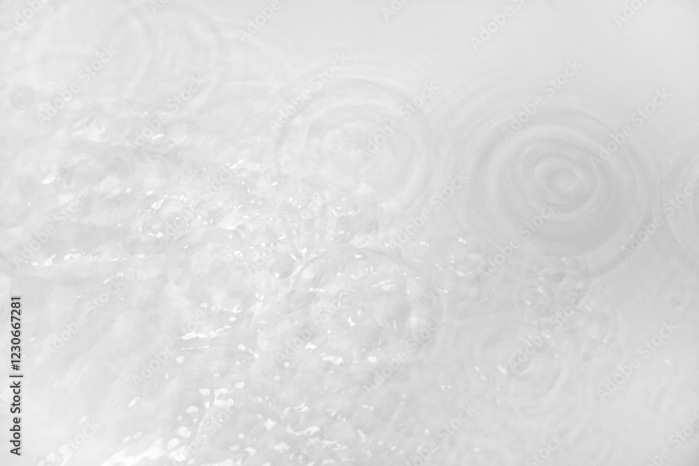 Background with clear white water. Top view, copy location, text location. Blurred background, transparent water surface with splashes and wave texture with ripples Background with clear white water. Top view, copy location, text location. Blurred background, transparent water surface with splashes and wave texture with ripples
