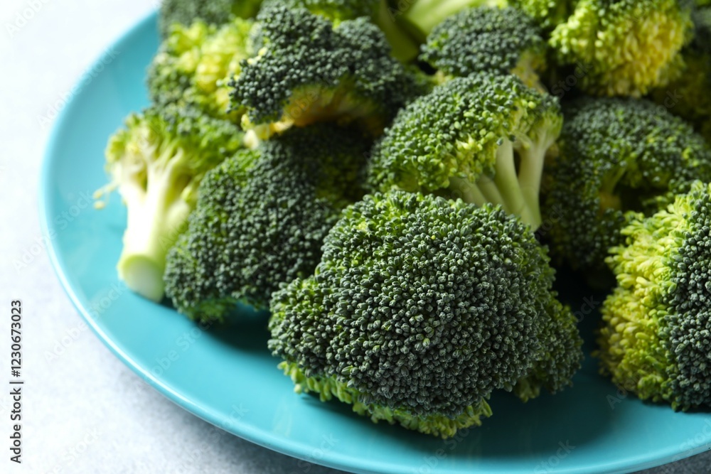 Fresh green broccoli in a plate on gray table Fresh green broccoli in a plate on gray table