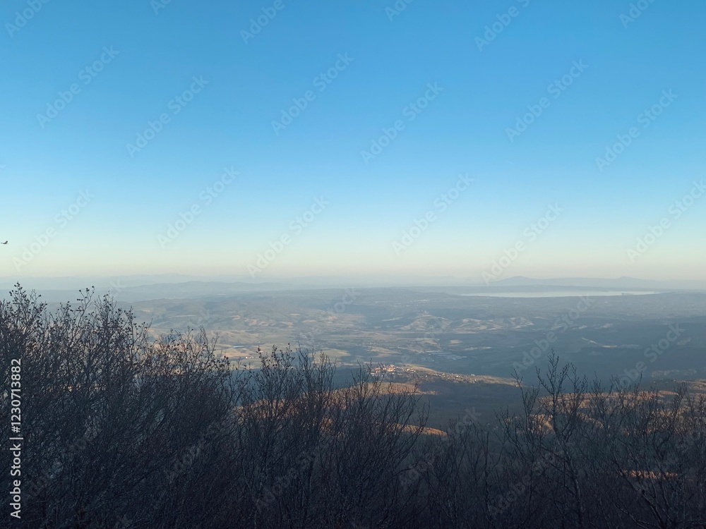 Fototapeta premium A panoramic view from a hilltop overlooking with a clear blue sky.