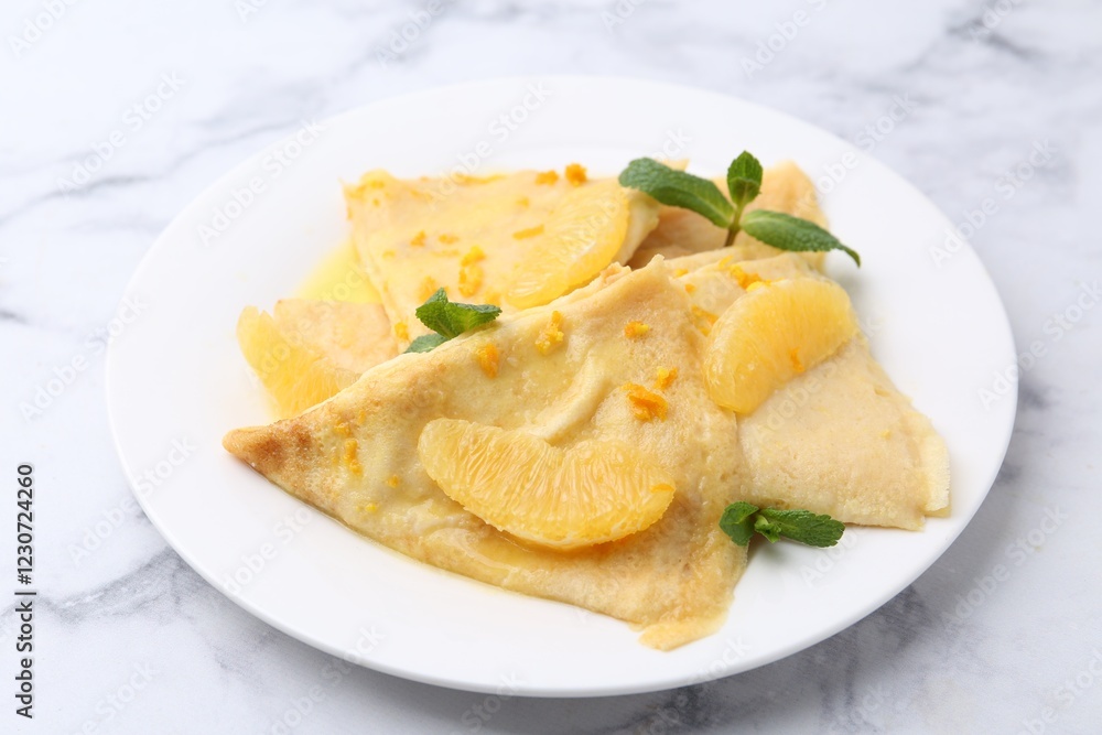 Plate with tasty crepes Suzette on white marble table, closeup Plate with tasty crepes Suzette on white marble table, closeup