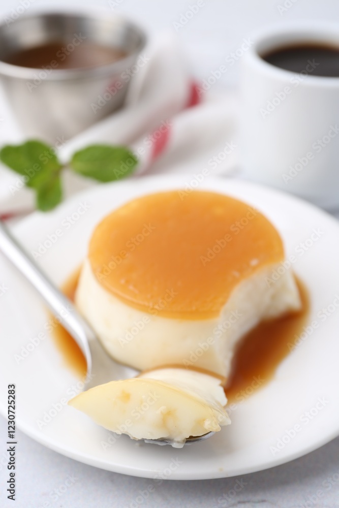 Tasty pudding with caramel sauce served on white textured table, closeup Tasty pudding with caramel sauce served on white textured table, closeup
