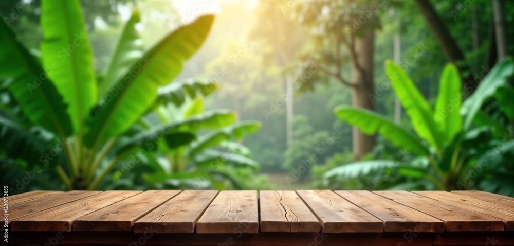 Obraz premium Wooden table sits in front of green jungle. Sunlight filters through banana trees, foliage. Peaceful, tranquil rural scene. Suitable for product placement, nature theme, eco lifestyle concepts. Ideal