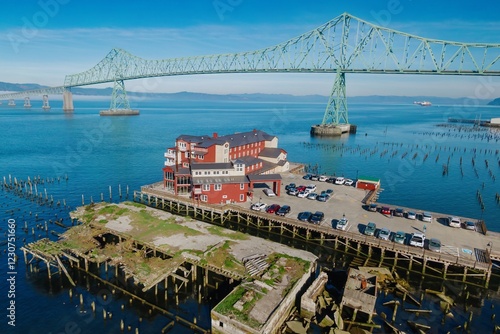 Tableau sur toile Aerial view of the Cannery Pier Hotel & Spa, a red building on a pier, with cars parked below
