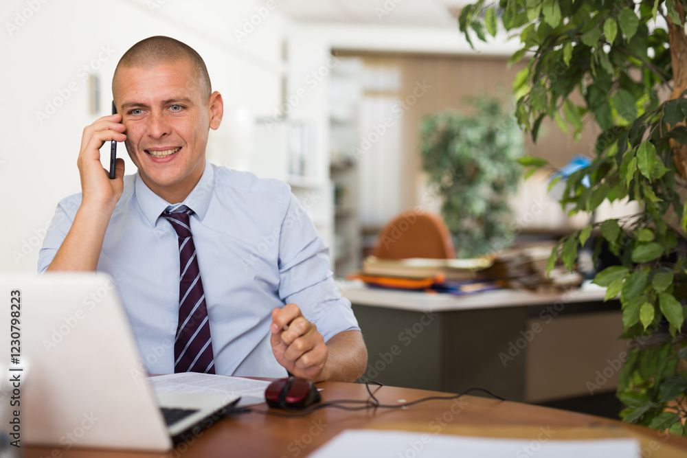 Portrait of male working in the office and talking on the phone Portrait of male working in the office and talking on the phone