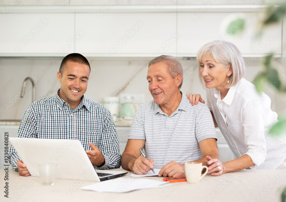 Couple of elderly man and woman while discussing deal with smiling male salesman in kitchen Couple of elderly man and woman while discussing deal with smiling male salesman in kitchen