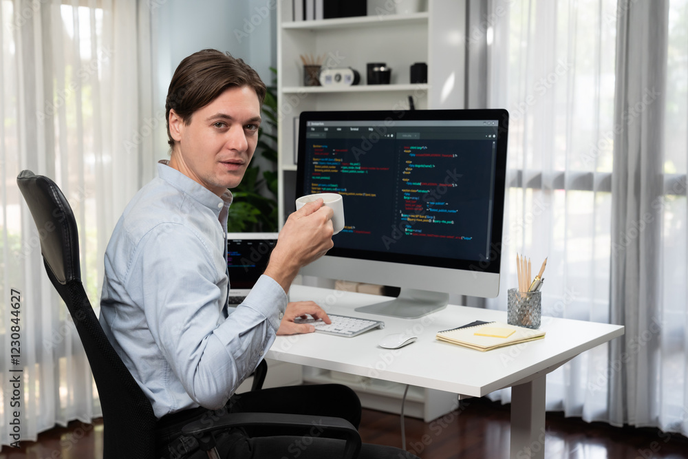 IT developer looking camera with holding coffee cup with online software on pc and laptop monitor beside, coding program on updated version application project creating new code system. Pecuniary. IT developer looking camera with holding coffee cup with online software on pc and laptop monitor beside, coding program on updated version application project creating new code system. Pecuniary.