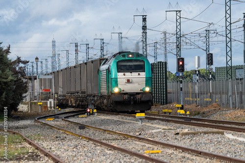 Modern freight train with a locomotive operated by a Spanish commercial rail company transporting paper pulp