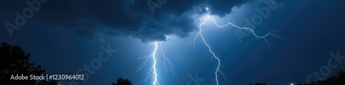 Lightning illuminates dark and foreboding stormy night skies, gray, bluishblack, nightsky photo