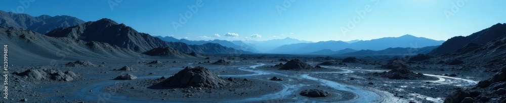 Rough cratered terrain with dark grey soil and distant blue sky, vast space, barren landscape, geological features Rough cratered terrain with dark grey soil and distant blue sky, vast space, barren landscape, geological features