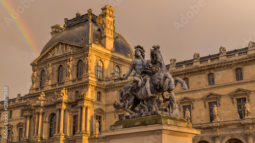 Louis XIV statue at the Louvre Museum - A closeup low-angle view of an Equestrian Statue of King Louis XIV at Cour Napoleon outside of the Louvre Museum on a stormy Spring evening. Paris, France.