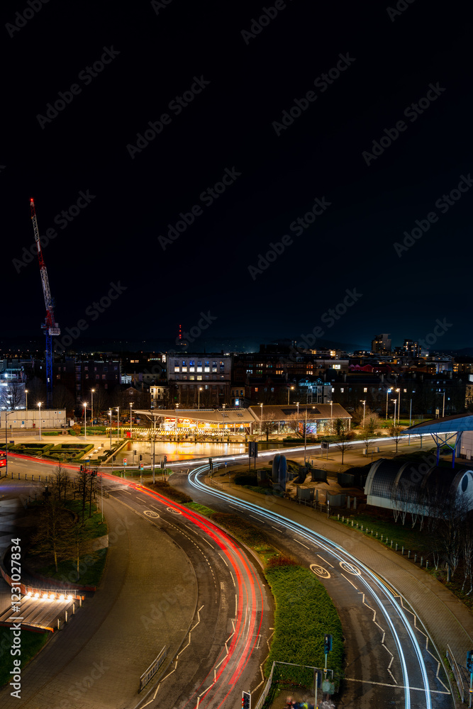 Obraz premium Cardiff city center at night with light trails from moving cars illuminating the urban landscape
