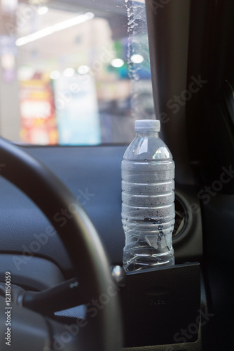 Water bottle placed on the car. Cup holder for water bottle in black car interior.