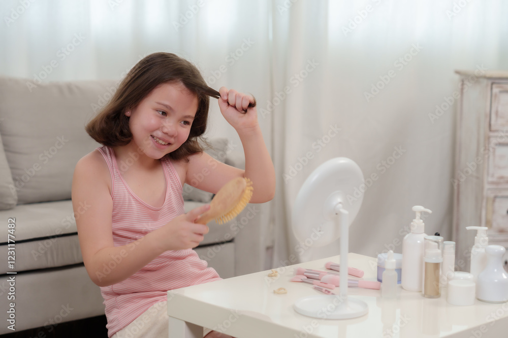 Cute Caucasian girl who loves beauty brushing long brown hair while smiling in front of a mirror. Sitting at a white table with beauty products, happily styling hair in a cozy home setting. Cute Caucasian girl who loves beauty brushing long brown hair while smiling in front of a mirror. Sitting at a white table with beauty products, happily styling hair in a cozy home setting.