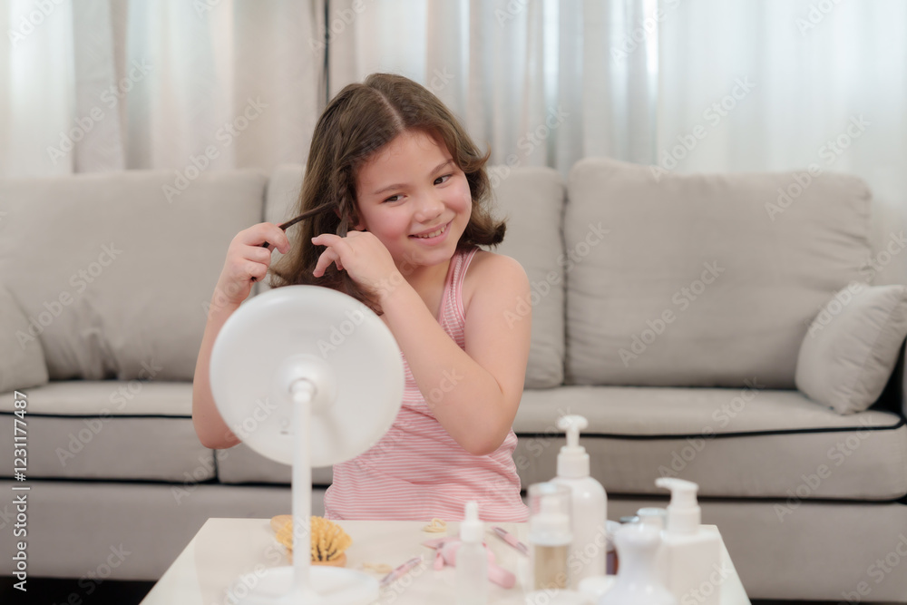 Cute Caucasian girl who loves beauty playing with curls while sitting in front of a mirror. Smiling with excitement, learning self-care and styling in a cozy home setting with beauty products. Cute Caucasian girl who loves beauty playing with curls while sitting in front of a mirror. Smiling with excitement, learning self-care and styling in a cozy home setting with beauty products.