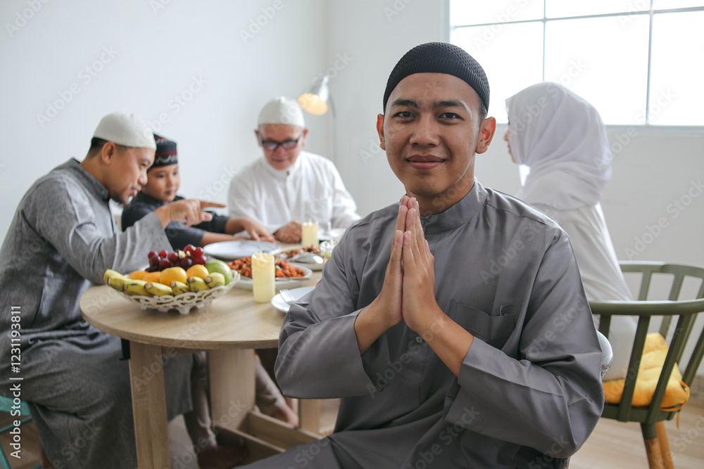 Portrait Of Young Muslim Man Gesture Forgiving Hands Against Blurry Background Of Family Togetherness Celebrating Eid Al Fitr Portrait Of Young Muslim Man Gesture Forgiving Hands Against Blurry Background Of Family Togetherness Celebrating Eid Al Fitr