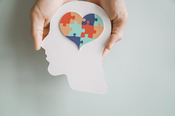 Hands holding jigsaw puzzle heart shape in brain Autism awareness, neurodiversity concept, World Autism Awareness Day.