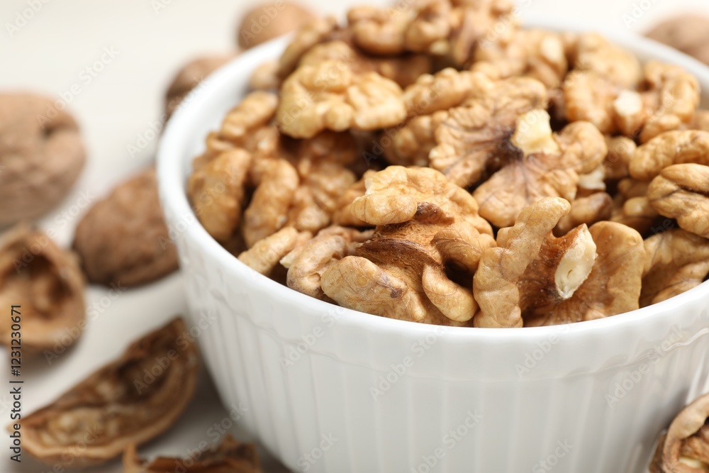Peeled walnuts in bowl on light table, closeup Peeled walnuts in bowl on light table, closeup
