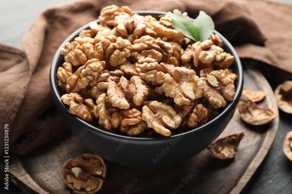 Fresh ripe walnuts in bowl on table, closeup Fresh ripe walnuts in bowl on table, closeup