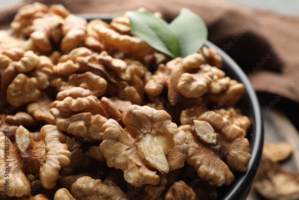 Fresh ripe walnuts in bowl on table, closeup Fresh ripe walnuts in bowl on table, closeup