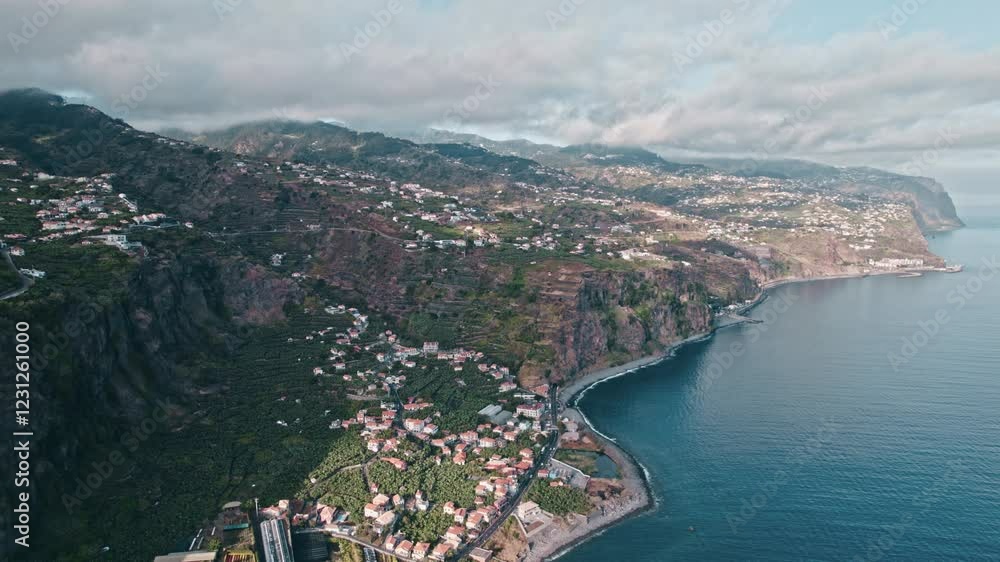 Madeira coastline view from the sea, villages, cloudy sky, Aerial, droneshot Madeira coastline view from the sea, villages, cloudy sky, Aerial, droneshot