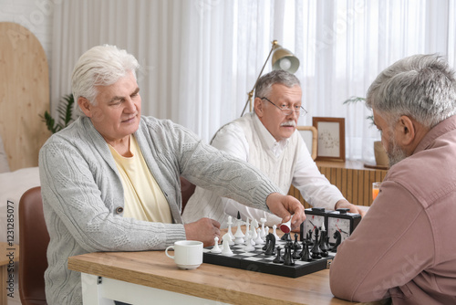 Elderly men playing cards a...