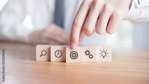 Businessman hand arranging wood block with icon business strategy and planning