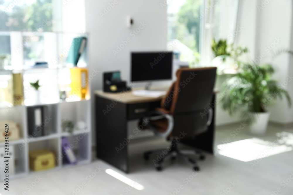 Interior of office with workplace, armchair, modern computer and shelving unit, blurred view Interior of office with workplace, armchair, modern computer and shelving unit, blurred view