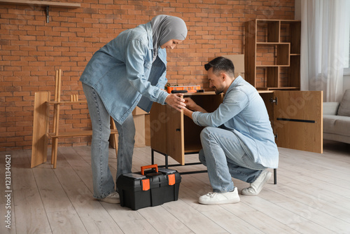 Tableau sur toile Muslim couple assembling chest of drawers at home