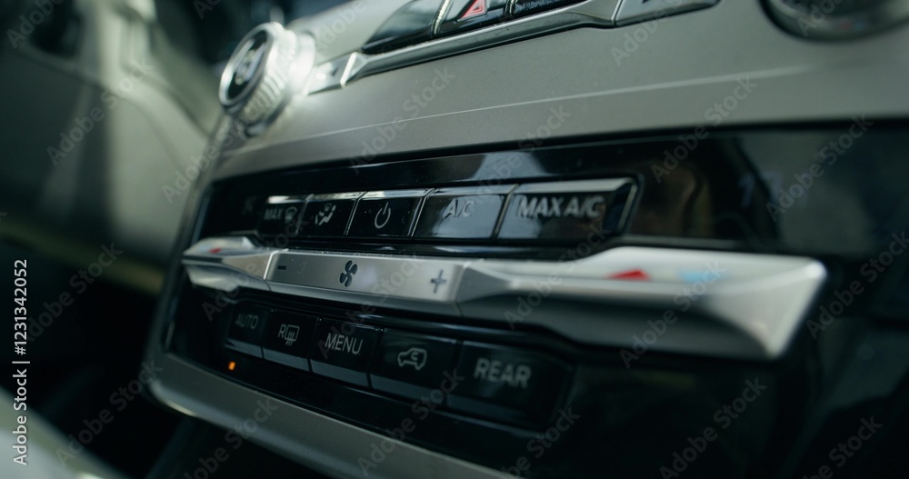 Obraz premium A woman's hand presses a button on the car's audio player while driving, close-up, unrecognizable person